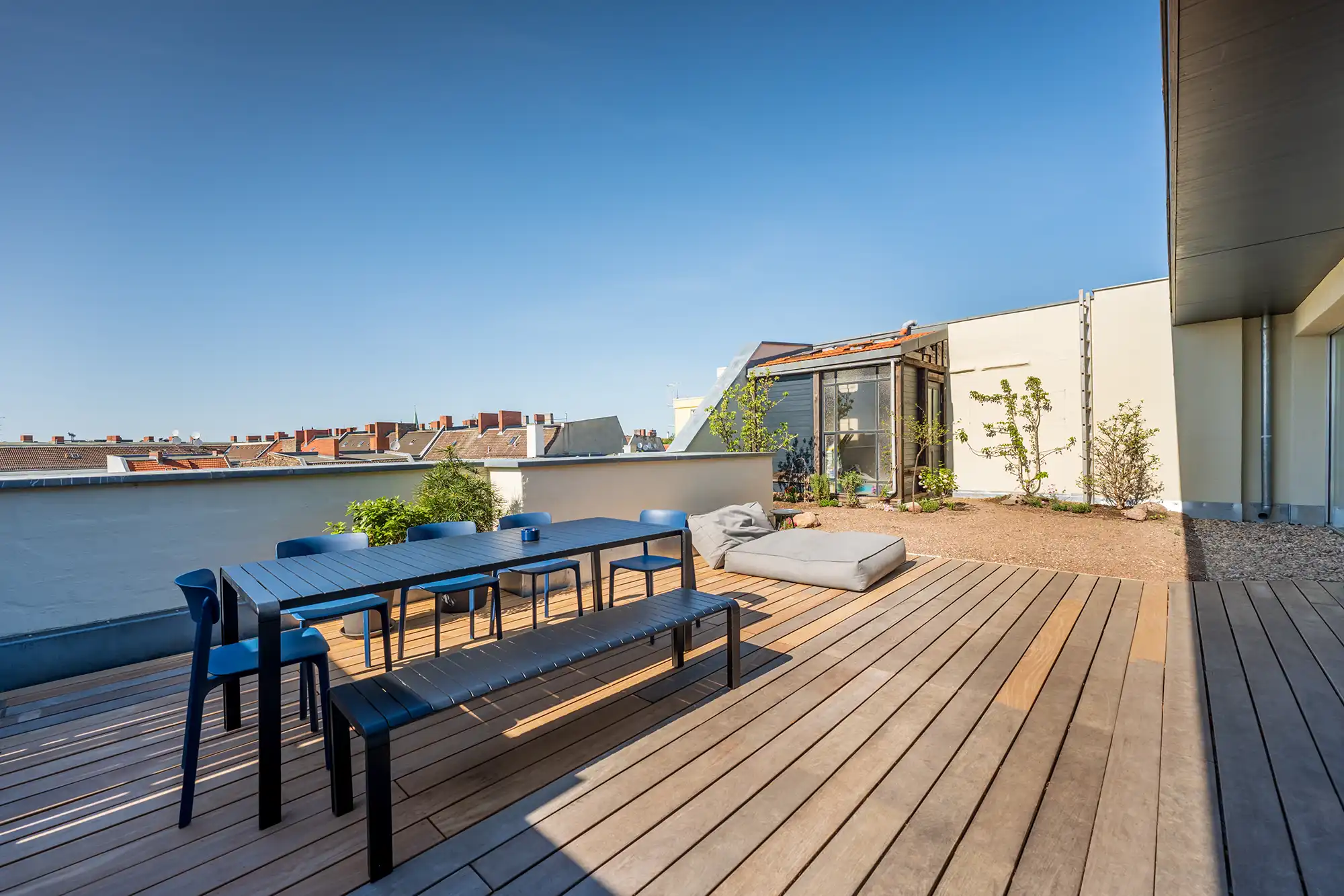 Große Dachterrasse mit Holzdielen, Esstisch, Sitzmöbeln und Pflanzbereich