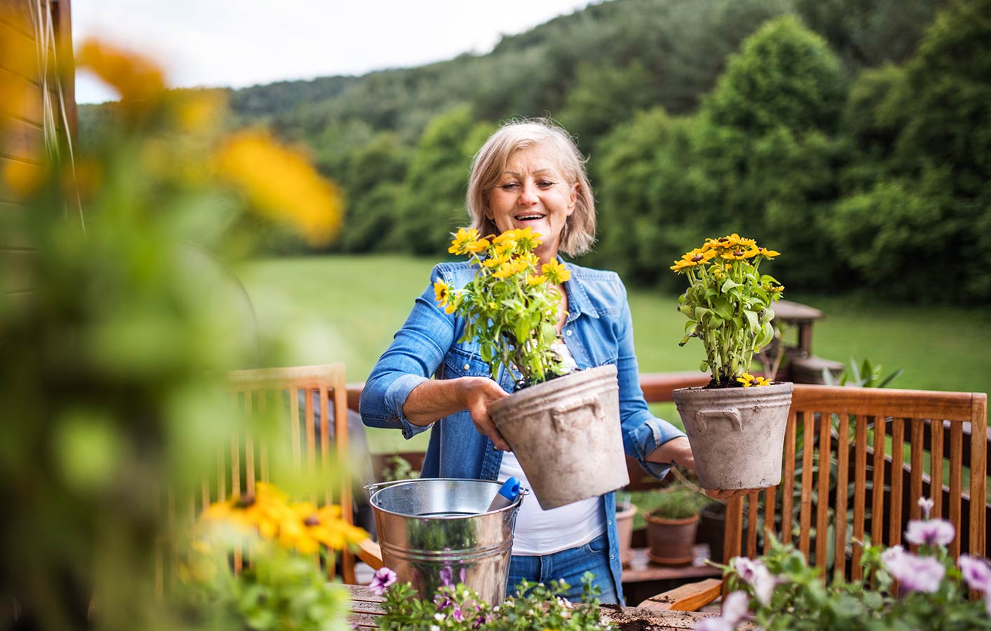 Ambiente für Ihren Garten und Terrasse Pflanztröge und Blumentröge ältere Dame bepflanzt Blumentöpfe auf Ihrer Terrasse