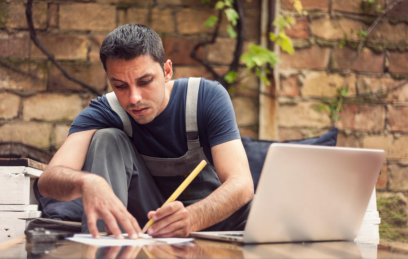 Handwerker bei der Planung mit Notebook und Papieren